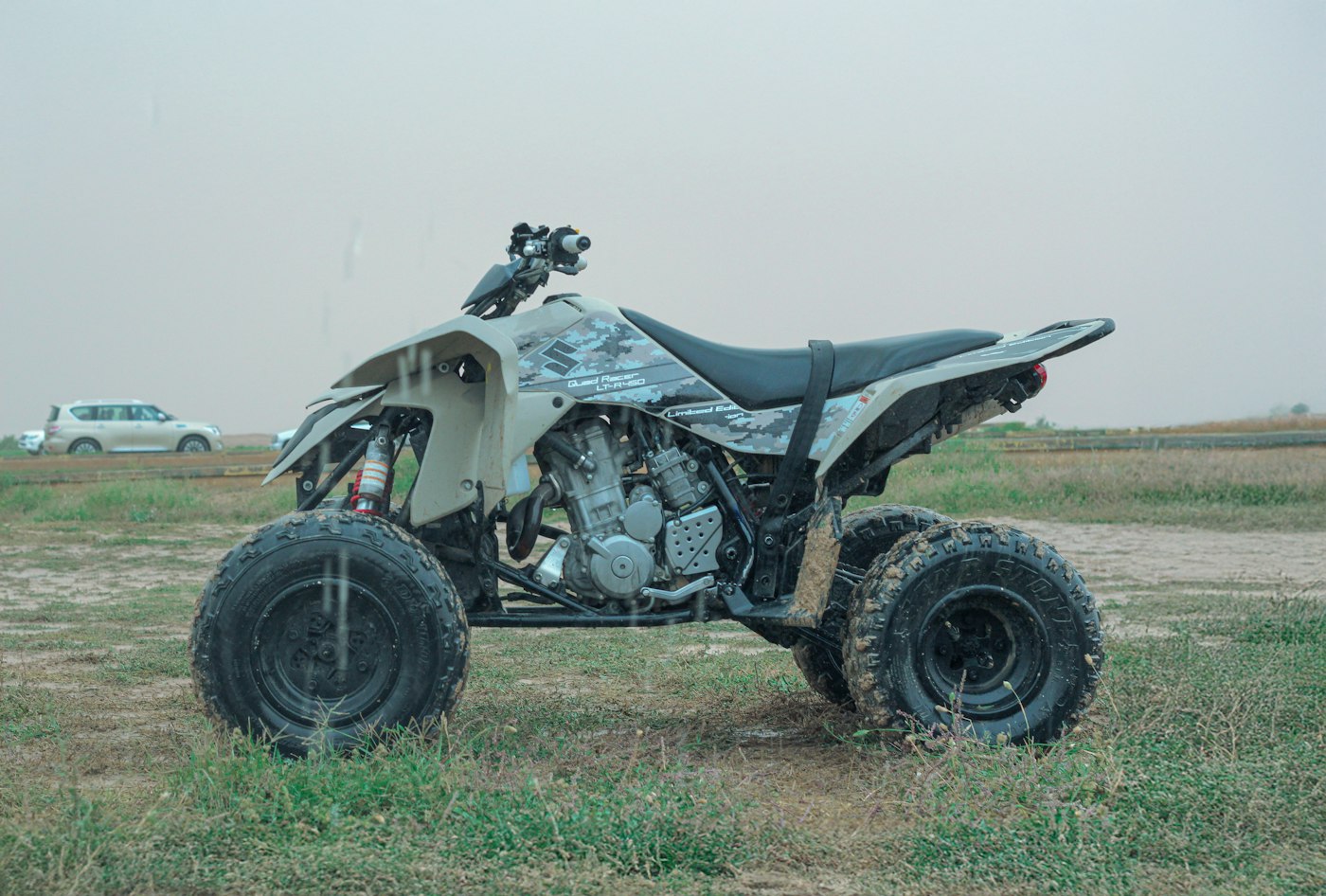 White ATV parked in a grassy field